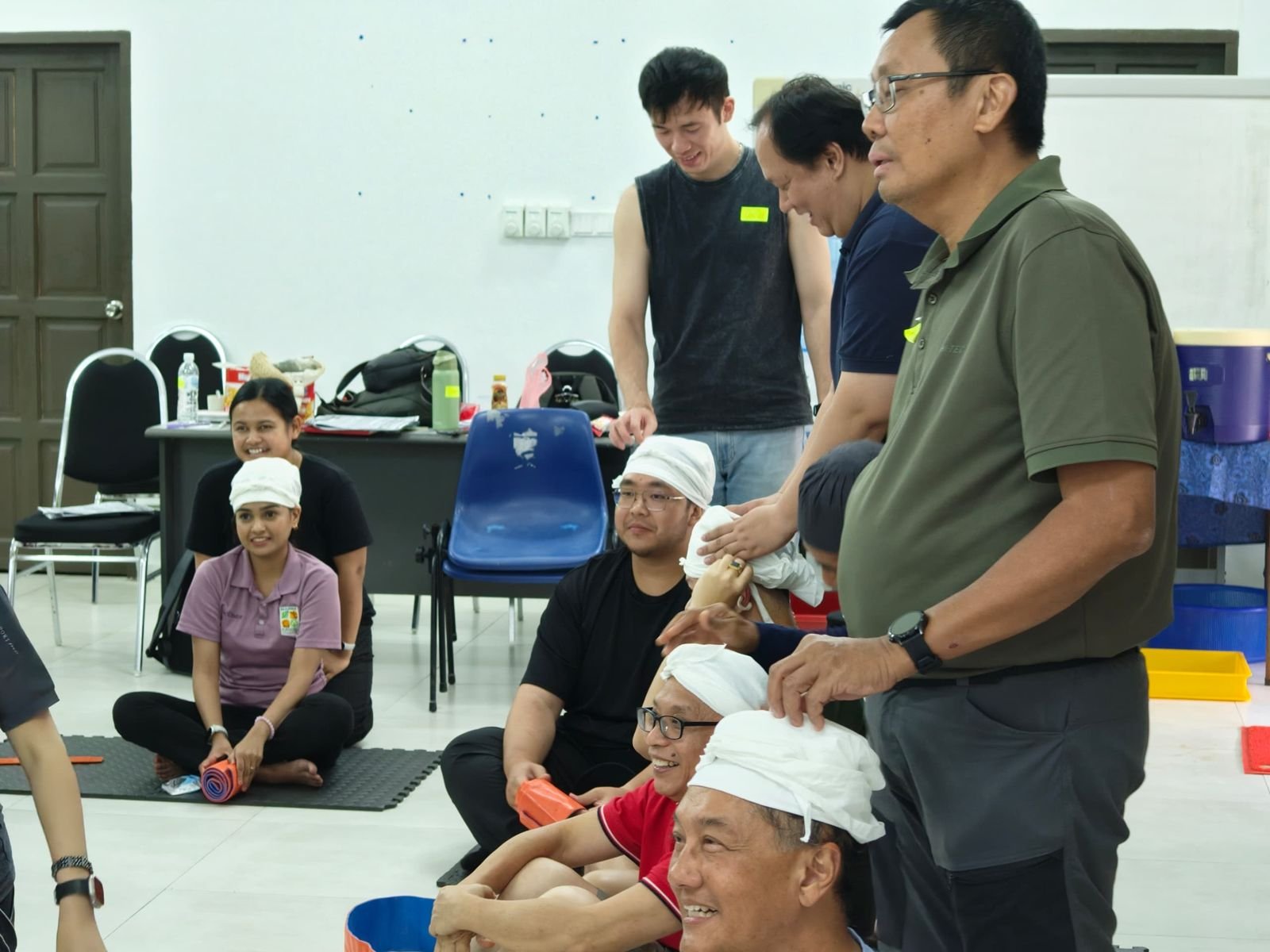 Trainees practising head and wound bandaging in a classroom